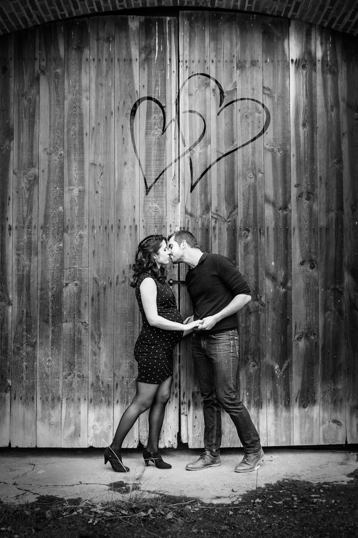 Photo Grossesse en couple amoureux devant porte de grange Elodie Frigot Photographe