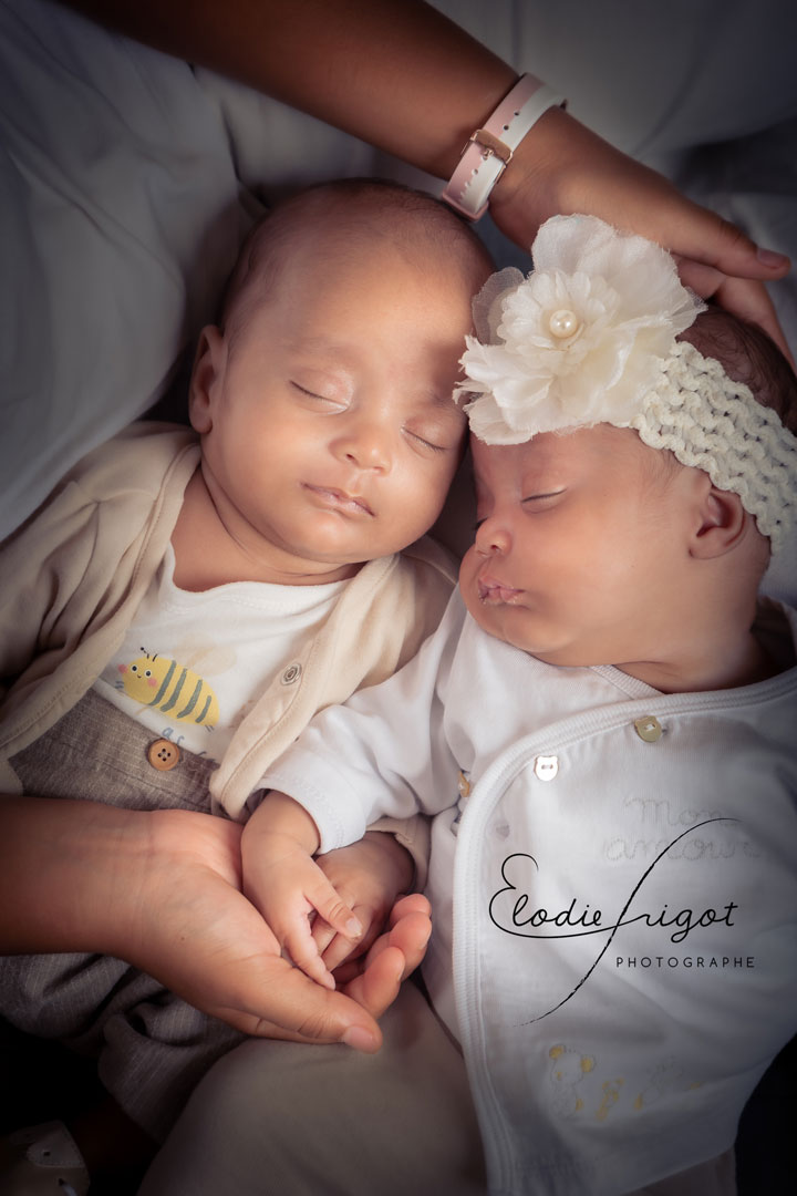 Photo de bébés jumeaux endormis dans les bras de leur soeur au studio Elodie Frigot Photographe