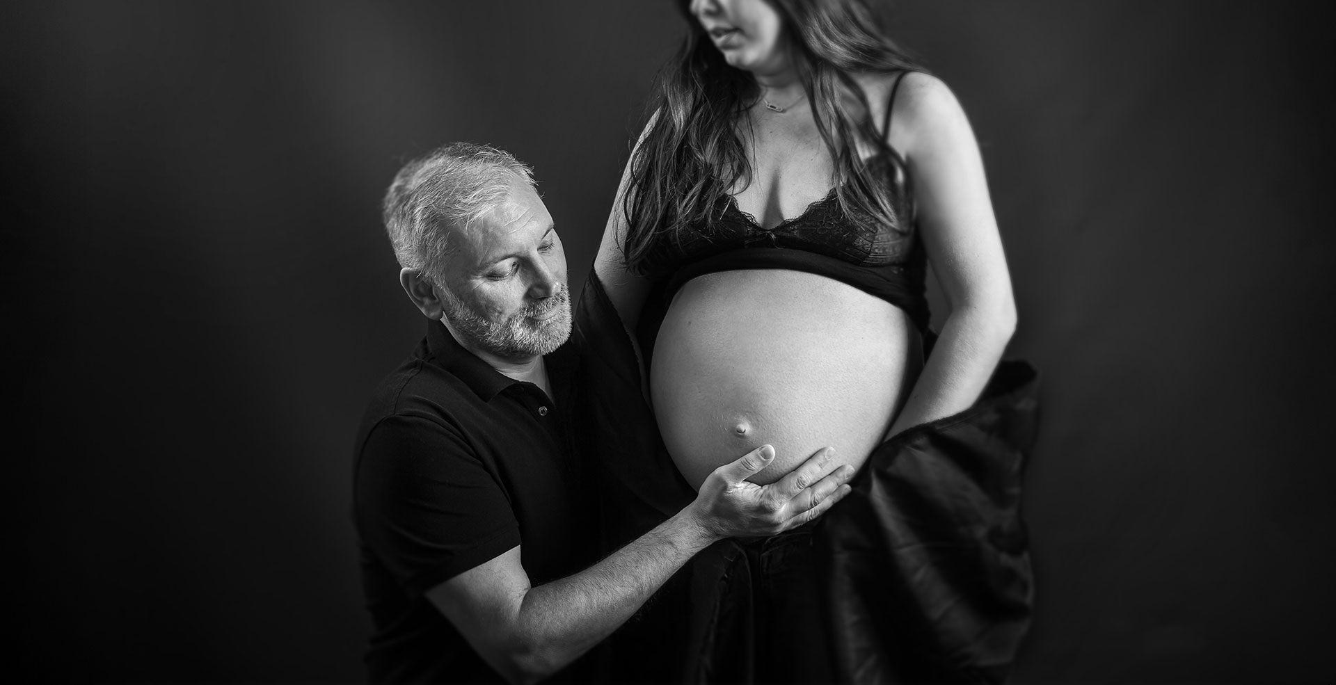 photo de grossesse futur papa caresse le ventre rond