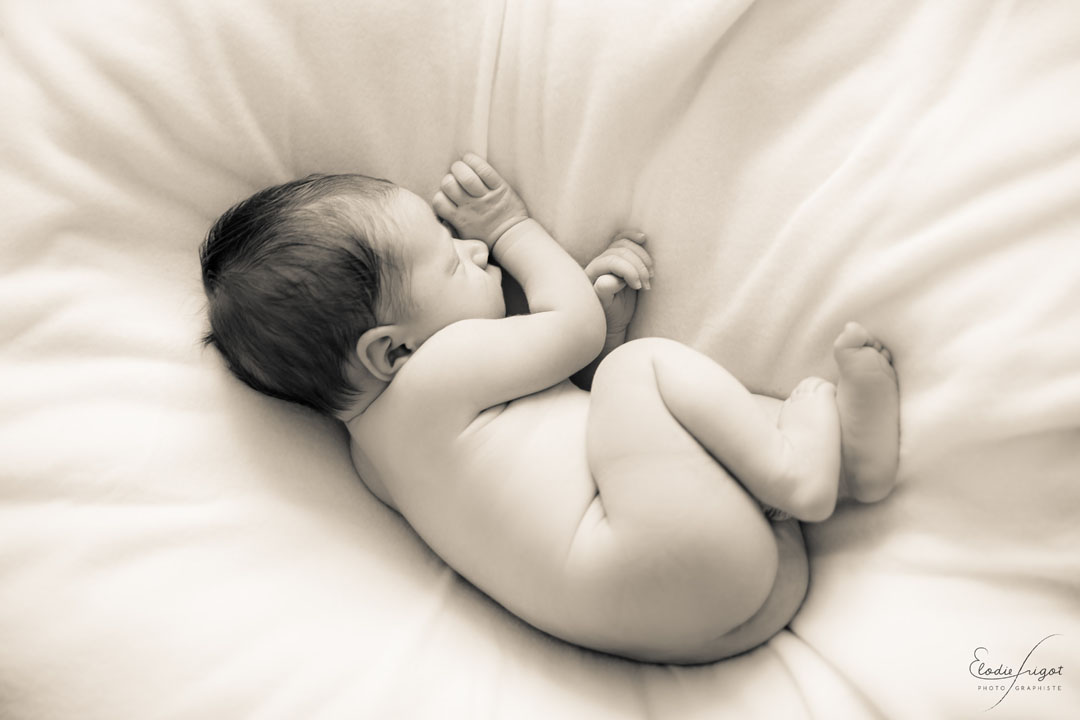 Photo de bébé nu endormi sur coussin à domicile Elodie Frigot Photographe