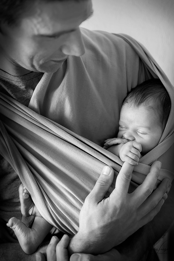 Photo de nouveau-né endormi dans l'écharpe de papa à la maison Elodie Frigot Photographe