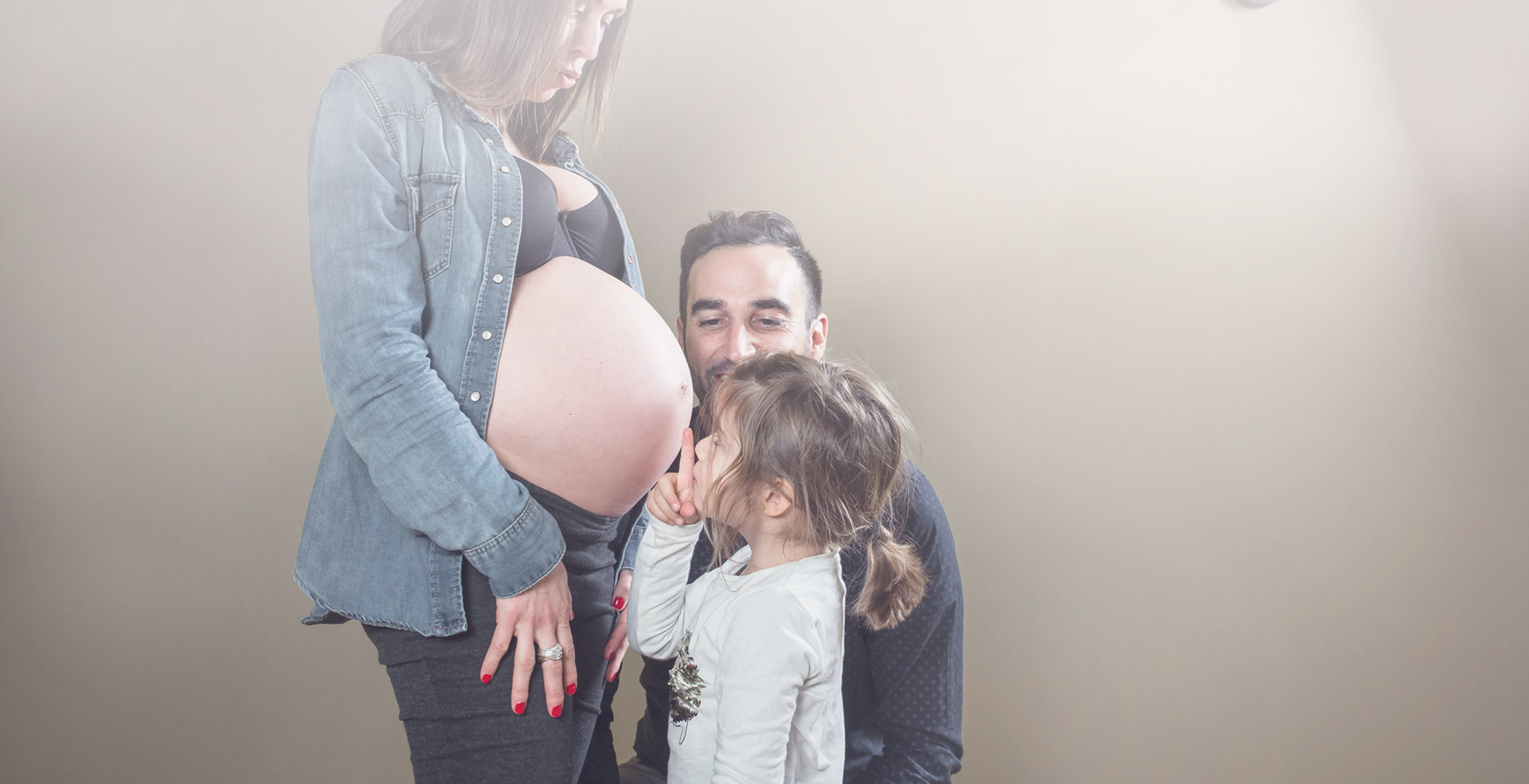photo de grossesse en famille avec bisou ventre rond