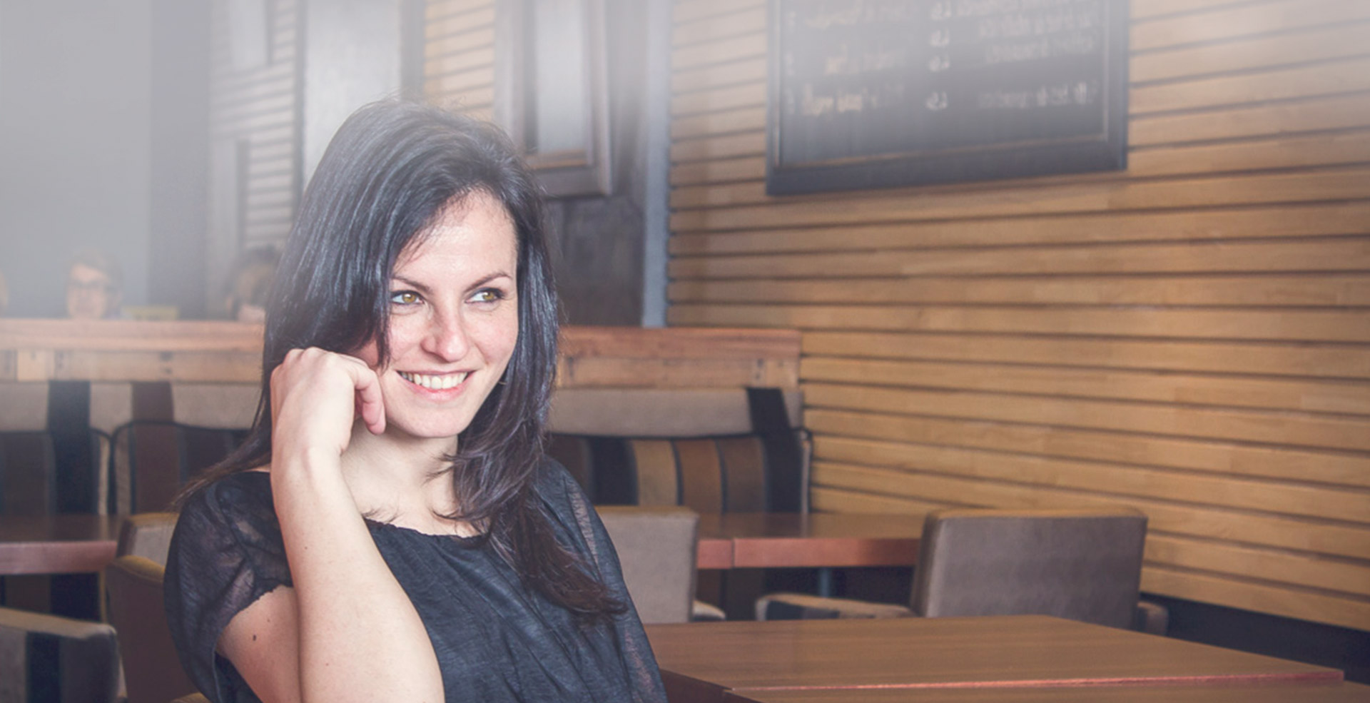 photo de modèle assise et souriante au café